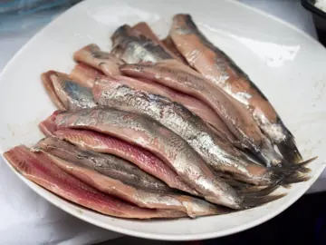 Soused herring fillets on a platter.