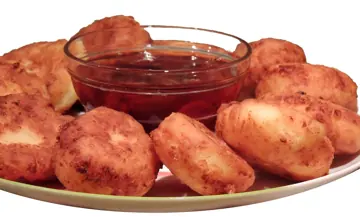 Syrnyky with a dipping sauce.