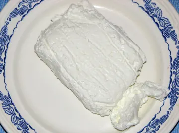 A block of fresh curd cheese.
